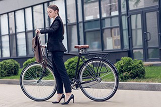 Junge Frau mit Aktentasche und Fahrrad